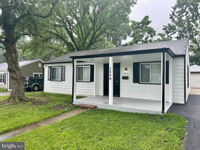 1239 Guildford Rd, Glen Burnie, MD 21060 - single story home featuring covered porch, a shingled roof, a front yard, and a garage