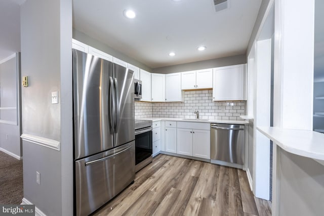 1537 Havilland Pl, Frederick, MD 21702 - kitchen with stainless steel appliances, white cabinets, light countertops, backsplash, and light wood finished floors