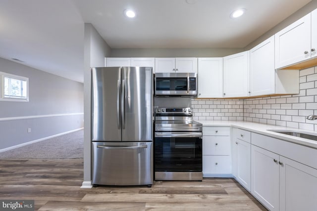 1537 Havilland Pl, Frederick, MD 21702 - kitchen featuring appliances with stainless steel finishes, light countertops, white cabinetry, backsplash, and light wood finished floors