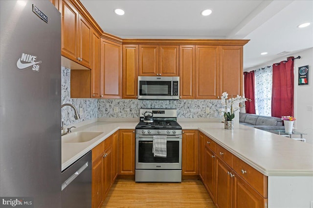 121 Kyle Way, Ewing, NJ 08628 - kitchen featuring stainless steel appliances, a peninsula, light wood-type flooring, light countertops, and tasteful backsplash