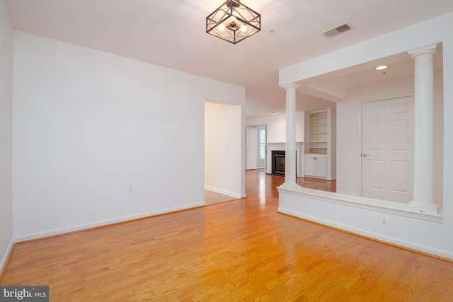 12030 Tralee Rd Unit 306, Lutherville Timonium, MD 21093 - unfurnished room with ornate columns, light wood-type flooring, a fireplace, and built in features