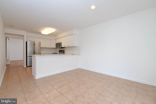 12030 Tralee Rd Unit 306, Lutherville Timonium, MD 21093 - kitchen featuring stainless steel appliances, light countertops, a peninsula, white cabinets, and recessed lighting