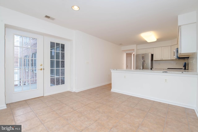12030 Tralee Rd Unit 306, Lutherville Timonium, MD 21093 - kitchen with freestanding refrigerator, light countertops, a peninsula, decorative backsplash, and recessed lighting