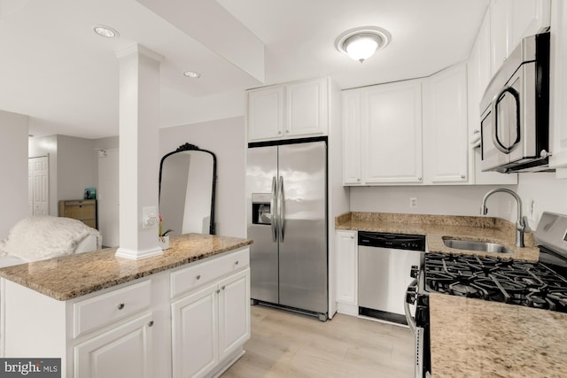 1200 S Arlington Ridge Rd Unit 507, Arlington, VA 22202 - kitchen featuring stainless steel appliances, white cabinetry, light stone countertops, light wood finished floors, and a center island