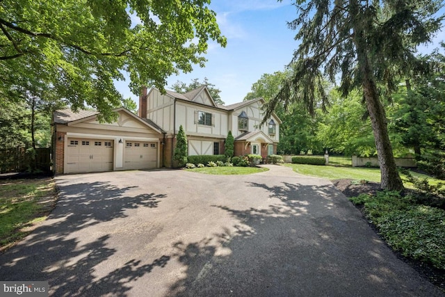 236 Carriage Hill Dr, Moorestown, NJ 08057 - tudor home featuring asphalt driveway, an attached garage, and brick siding