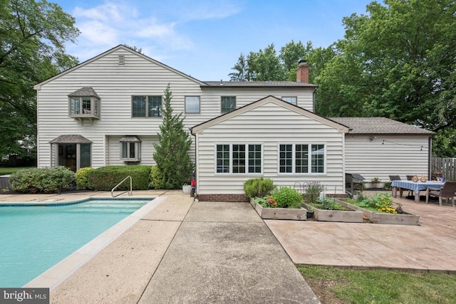 236 Carriage Hill Dr, Moorestown, NJ 08057 - back of property with a patio area, an outdoor pool, and a chimney
