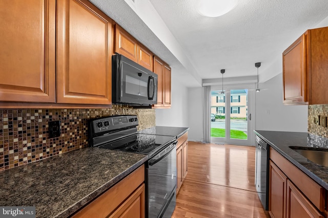 2 Brookshire Dr Unit A, Reisterstown, MD 21136 - kitchen with black appliances, light wood finished floors, brown cabinets, backsplash, and decorative light fixtures