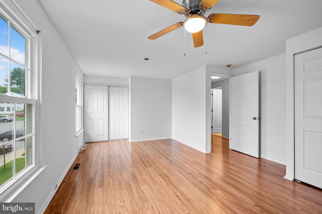 2 Brookshire Dr Unit A, Reisterstown, MD 21136 - unfurnished bedroom with light wood-type flooring, multiple windows, a closet, and a ceiling fan