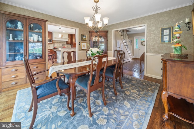 4105 Meadow Ln, Newtown Square, PA 19073 - dining room featuring dark wood-type flooring, a chandelier, stairway, wallpapered walls, and ornamental molding