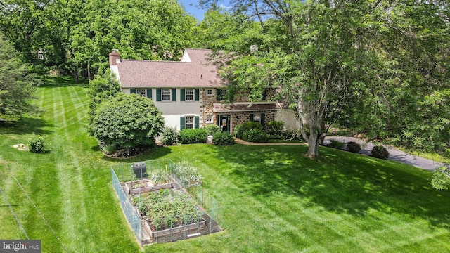 4105 Meadow Ln, Newtown Square, PA 19073 - view of front of home with a vegetable garden, a front lawn, stucco siding, and a chimney