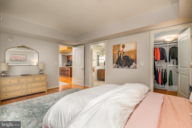 1025 1st St SE Unit 713, Washington, DC 20003 - bedroom featuring a walk in closet, a closet, light wood-style floors, and ensuite bath