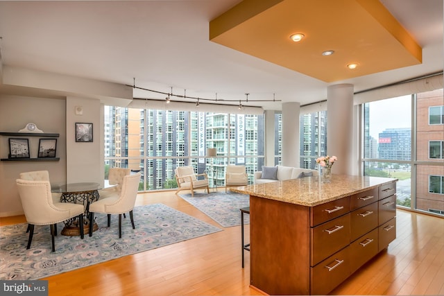 1025 1st St SE Unit 713, Washington, DC 20003 - kitchen with light wood finished floors, a center island, a kitchen bar, recessed lighting, and light stone counters