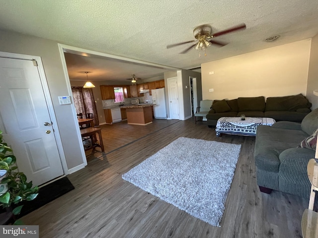 103 N W St, Harrington, DE 19952 - living area featuring dark wood-style floors, ceiling fan, and a textured ceiling