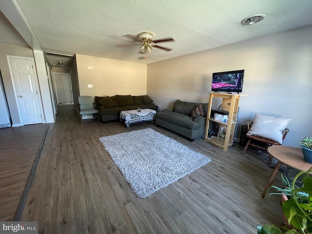 103 N W St, Harrington, DE 19952 - living room with dark wood-style floors, a ceiling fan, and a textured ceiling