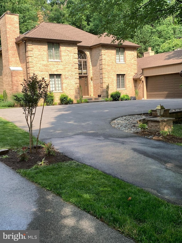6160 Wooded Run Dr, Columbia, MD 21044 - view of front of property with driveway, a chimney, a garage, and a shingled roof