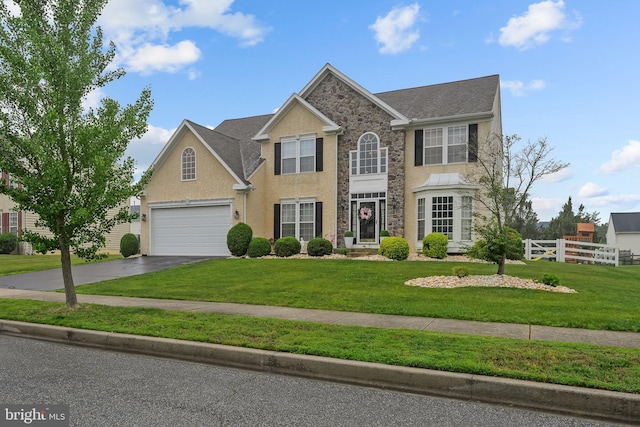 734 Wood Duck Ct, Middletown, DE 19709 - view of front of home featuring stone siding, concrete driveway, stucco siding, and a shingled roof