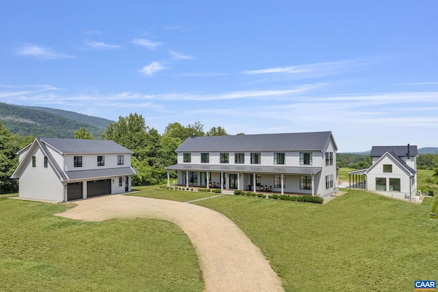 310 Goodloe Ln, Afton, VA 22920 - view of front of house featuring covered porch, a front lawn, driveway, a metal roof, and a garage