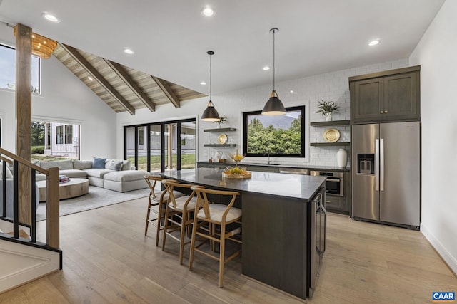 310 Goodloe Ln, Afton, VA 22920 - kitchen with stainless steel appliances, open shelves, a center island, light wood finished floors, and a breakfast bar