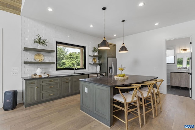 310 Goodloe Ln, Afton, VA 22920 - kitchen featuring open shelves, appliances with stainless steel finishes, light wood-style flooring, a center island, and a kitchen bar