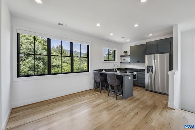 310 Goodloe Ln, Afton, VA 22920 - kitchen featuring appliances with stainless steel finishes, open shelves, a peninsula, a kitchen bar, and light wood-type flooring