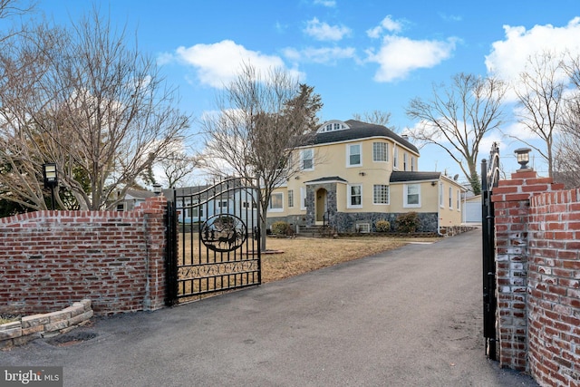 34 Harvard Rd, Hagerstown, MD 21742 - view of front of house with a gate, stucco siding, stone siding, and driveway