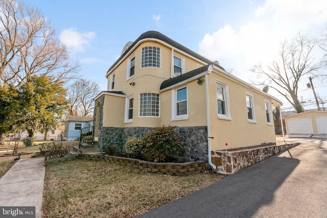 34 Harvard Rd, Hagerstown, MD 21742 - view of side of home featuring an outbuilding, stone siding, stucco siding, and a detached garage