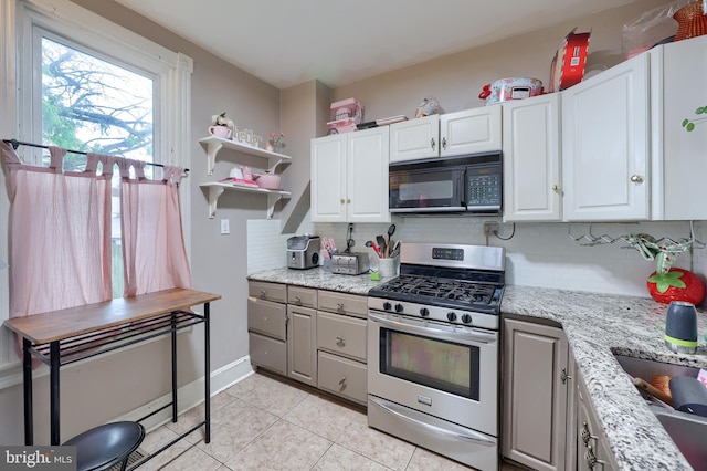 305 N Market St, Elizabethtown, PA 17022 - kitchen featuring stainless steel gas stove, black microwave, tasteful backsplash, white cabinets, and light tile patterned floors