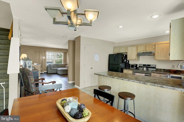 309 Lincoln Ave, Harrisburg, PA 17111 - kitchen featuring stainless steel appliances, under cabinet range hood, light tile patterned floors, a peninsula, and dark countertops
