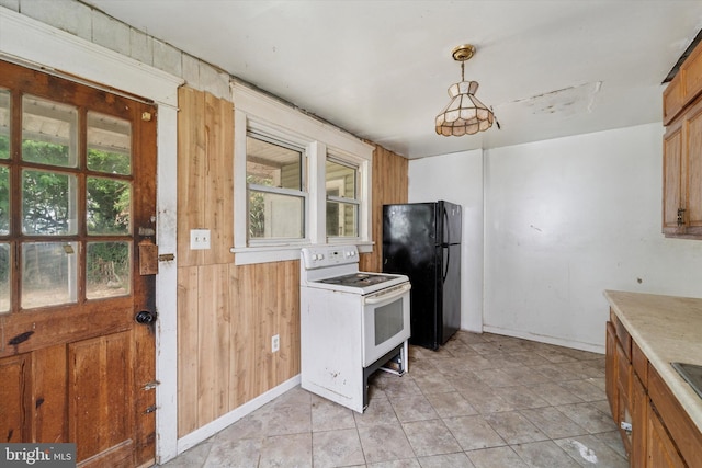 59 Pine St, Beverly, NJ 08010 - kitchen featuring white range with electric stovetop, freestanding refrigerator, wooden walls, brown cabinets, and light countertops