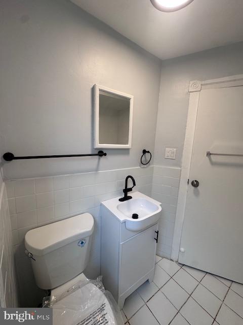 3302 N Palethorp St, Philadelphia, PA 19140 - bathroom featuring vanity, tile walls, tile patterned flooring, and a wainscoted wall