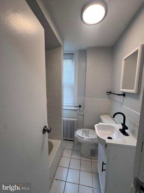 3302 N Palethorp St, Philadelphia, PA 19140 - full bathroom with radiator, tile patterned flooring, vanity, a tub, and tile walls