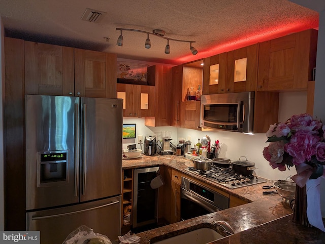 1720 Lake Shore Crest Dr Unit 34, Reston, VA 20190 - kitchen with stainless steel appliances, wine cooler, light stone counters, and brown cabinetry