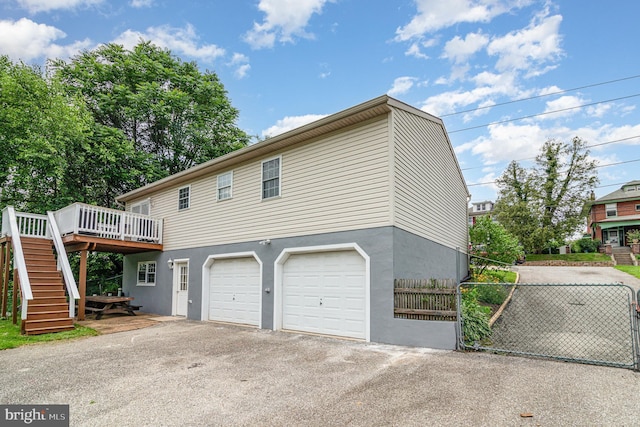 463 Maple St, Manchester, PA 17345 - view of front facade with a deck, stairs, asphalt driveway, a garage, and stucco siding