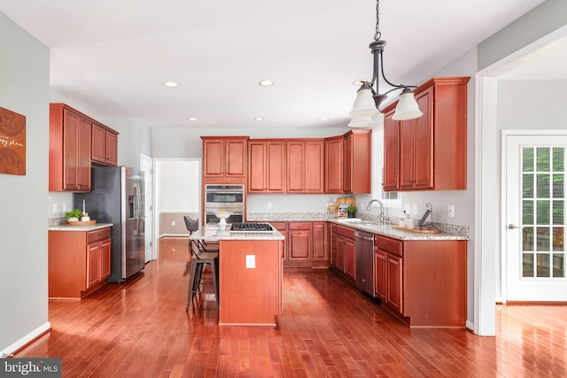 173 Empress Alexandra Pl, Fredericksburg, VA 22406 - kitchen with stainless steel appliances, a kitchen island, a breakfast bar area, wood finished floors, and recessed lighting