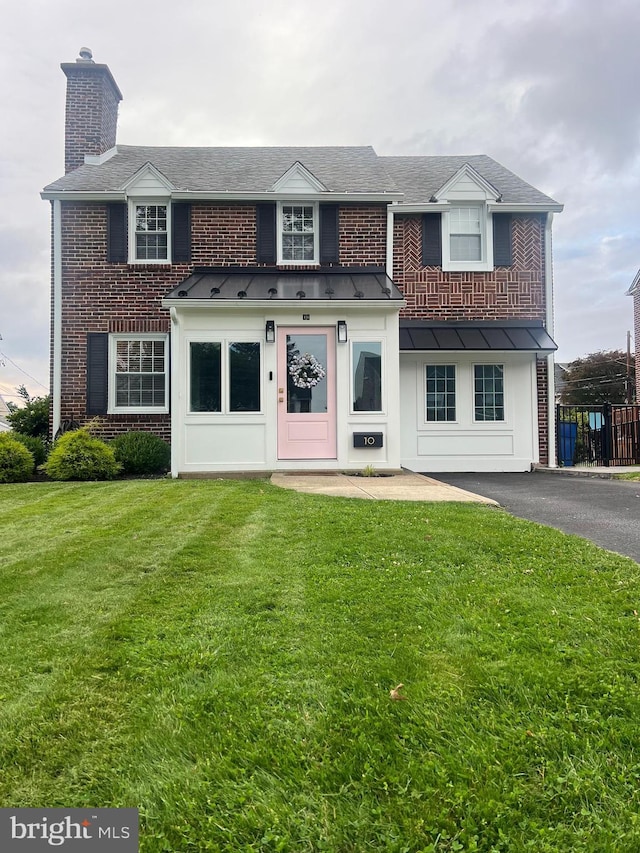 10 Braeburn Rd, Havertown, PA 19083 - view of front facade with a standing seam roof, brick siding, a front yard, and a chimney