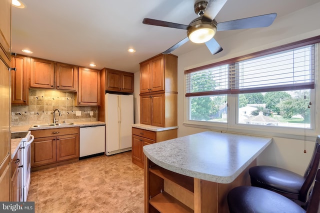 1 Sherman St, Hanover, PA 17331 - kitchen featuring white appliances, light countertops, ceiling fan, brown cabinetry, and decorative backsplash