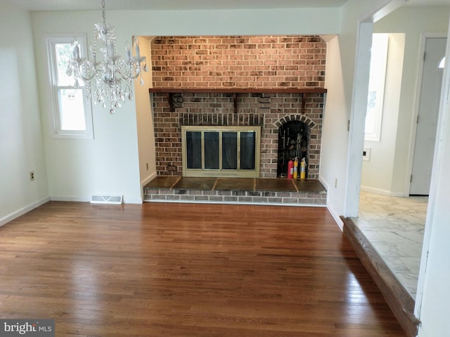 512 Mifflin Blvd, Reading, PA 19607 - unfurnished living room with wood finished floors, a fireplace, and a chandelier