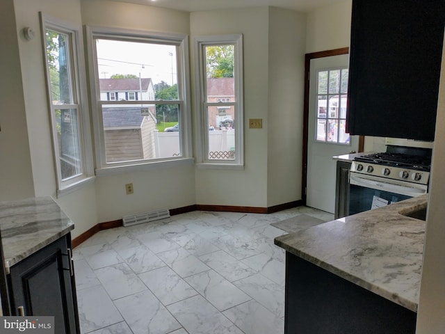 512 Mifflin Blvd, Reading, PA 19607 - kitchen with gas range, light marble finish flooring, light stone counters, and dark cabinets