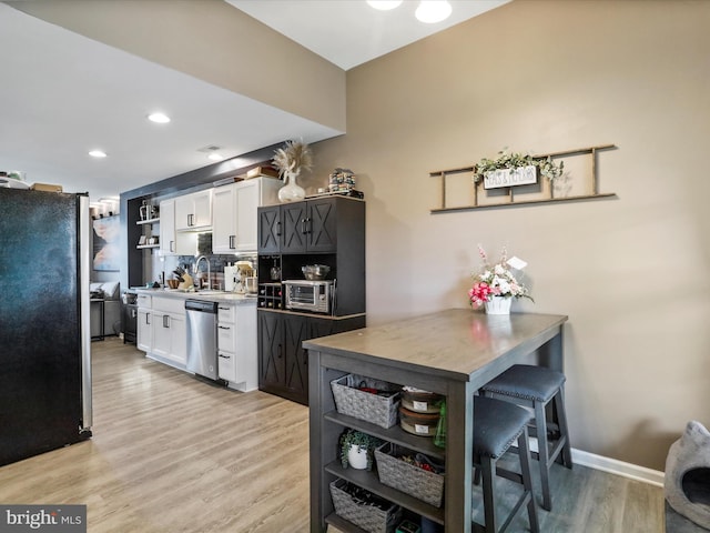 309 Legion St, Martinsburg, WV 25404 - kitchen with freestanding refrigerator, open shelves, dishwasher, white cabinetry, and tasteful backsplash
