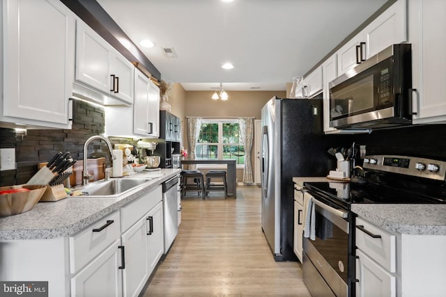 309 Legion St, Martinsburg, WV 25404 - kitchen featuring stainless steel appliances, white cabinetry, light wood finished floors, tasteful backsplash, and recessed lighting