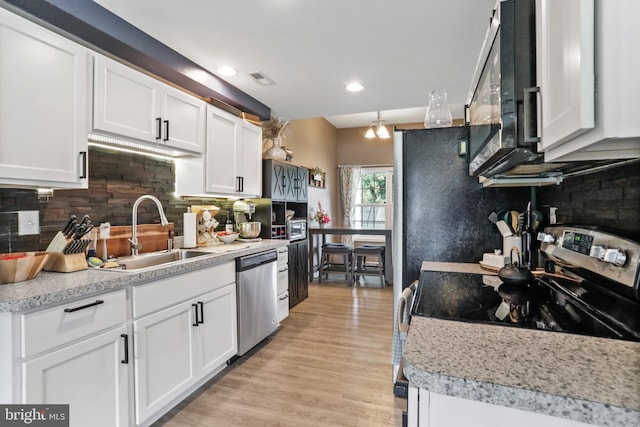 309 Legion St, Martinsburg, WV 25404 - kitchen featuring stainless steel appliances, white cabinets, light countertops, tasteful backsplash, and recessed lighting