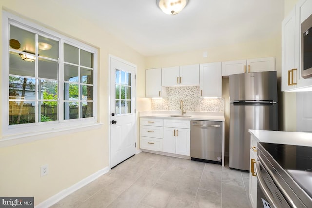 804 Gregorio Dr, Silver Spring, MD 20901 - kitchen with stainless steel appliances, white cabinets, light countertops, backsplash, and light tile patterned flooring