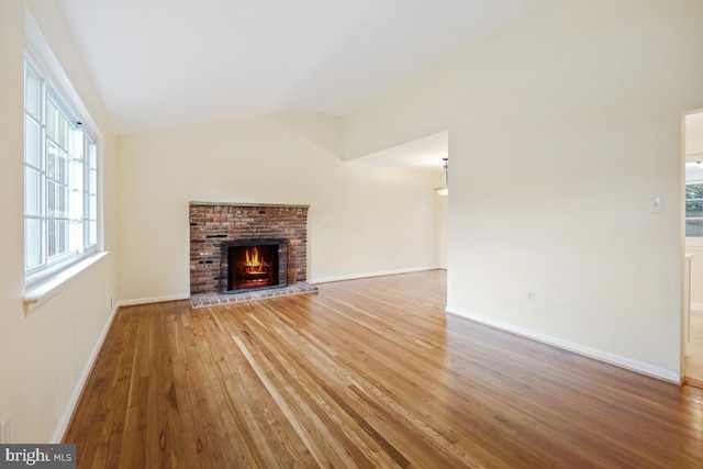 804 Gregorio Dr, Silver Spring, MD 20901 - unfurnished living room featuring wood finished floors, vaulted ceiling, and a brick fireplace