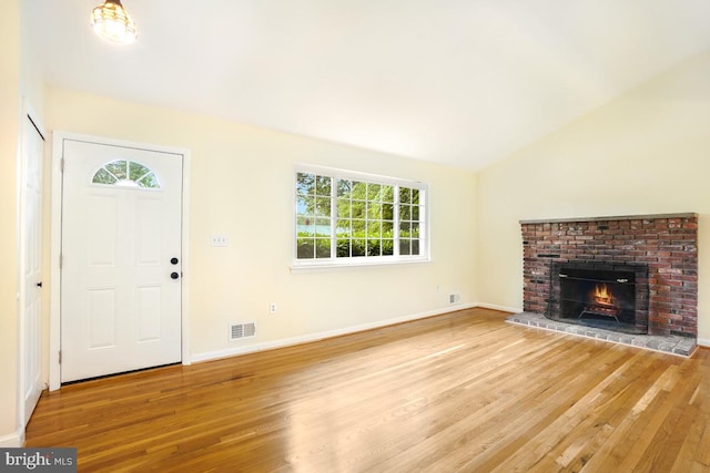 804 Gregorio Dr, Silver Spring, MD 20901 - unfurnished living room featuring light wood-style flooring, lofted ceiling, plenty of natural light, and a brick fireplace