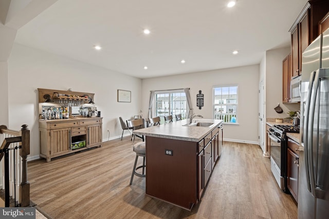 213 Dalton, Woolwich Twp, NJ 08085 - kitchen with range with gas cooktop, light wood-style floors, an island with sink, a kitchen breakfast bar, and freestanding refrigerator