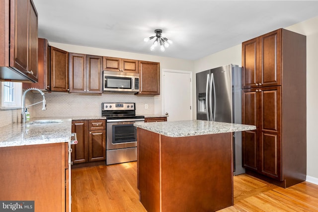 310 E Charlotte St, Millersville, PA 17551 - kitchen featuring stainless steel appliances, light wood finished floors, tasteful backsplash, and a center island