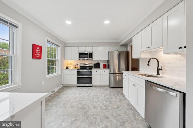 121 Harrison St NE, Leesburg, VA 20176 - kitchen featuring appliances with stainless steel finishes, ornamental molding, tasteful backsplash, white cabinetry, and light stone countertops
