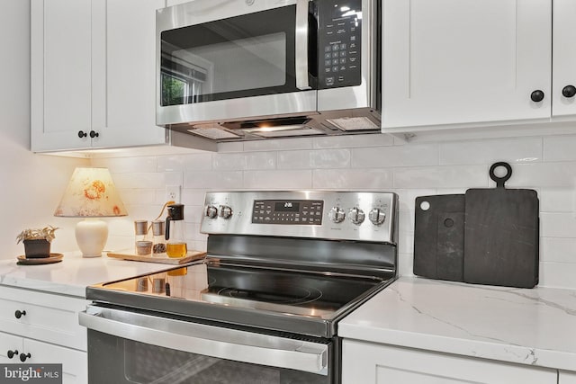 121 Harrison St NE, Leesburg, VA 20176 - kitchen with stainless steel appliances, tasteful backsplash, white cabinets, and light stone counters
