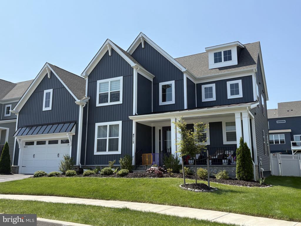 4712 Hazelnut Ct, Monrovia, MD 21770 - modern farmhouse featuring a porch, a standing seam roof, a garage, and board and batten siding