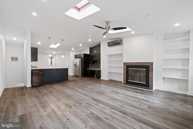 1805 Chestnut St, Philadelphia, PA 19103 - unfurnished living room with a skylight, an AC wall unit, built in shelves, wood finished floors, and recessed lighting